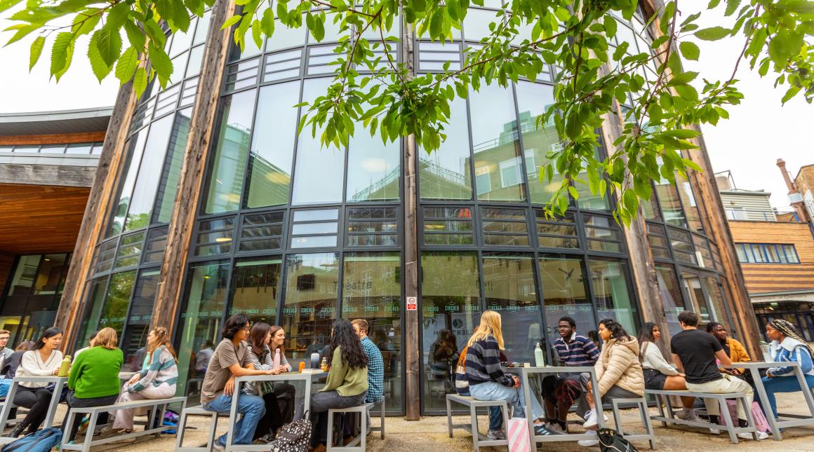 Students sitting outside a Durham University campus building