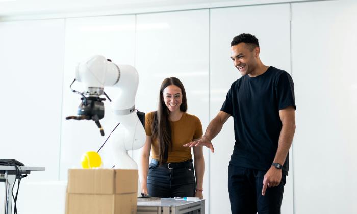 Engineers working with a robotic arm
