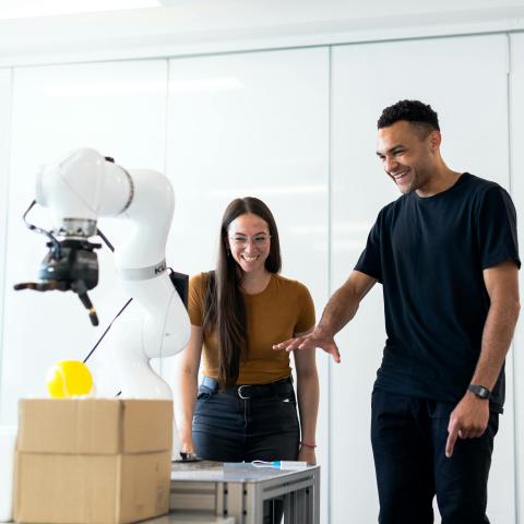 Engineers working with a robotic arm
