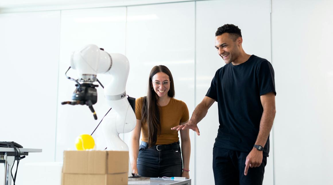 Engineers working with a robotic arm