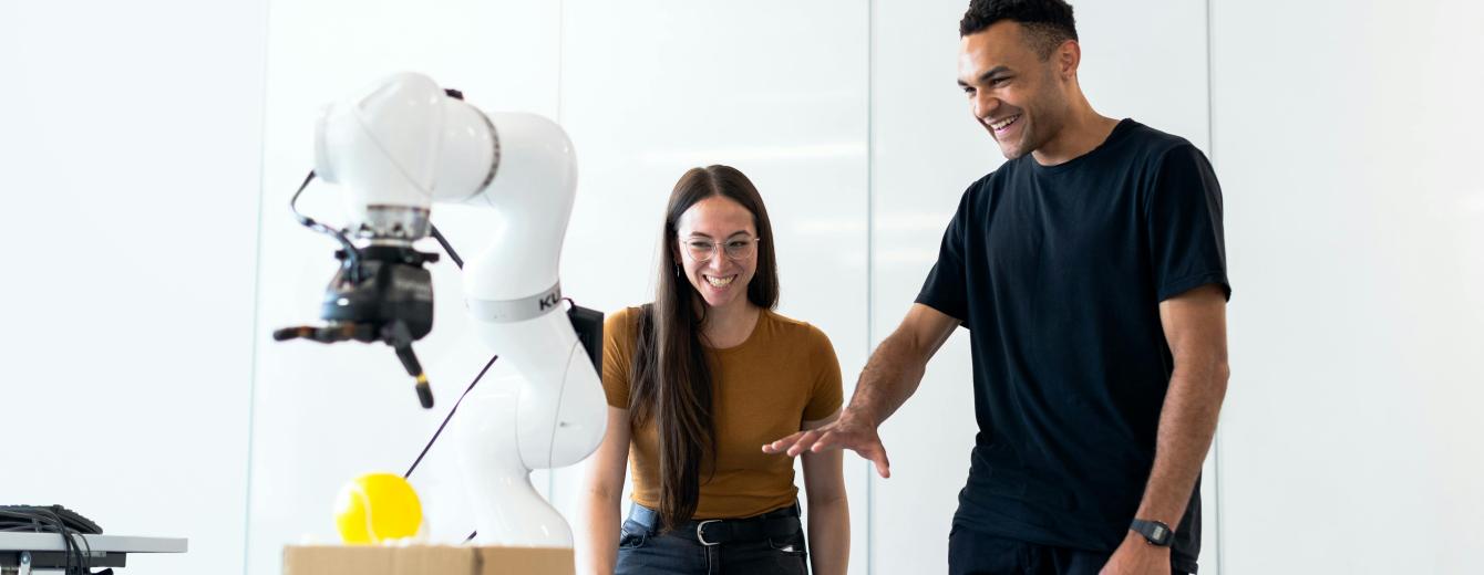 Engineers working with a robotic arm