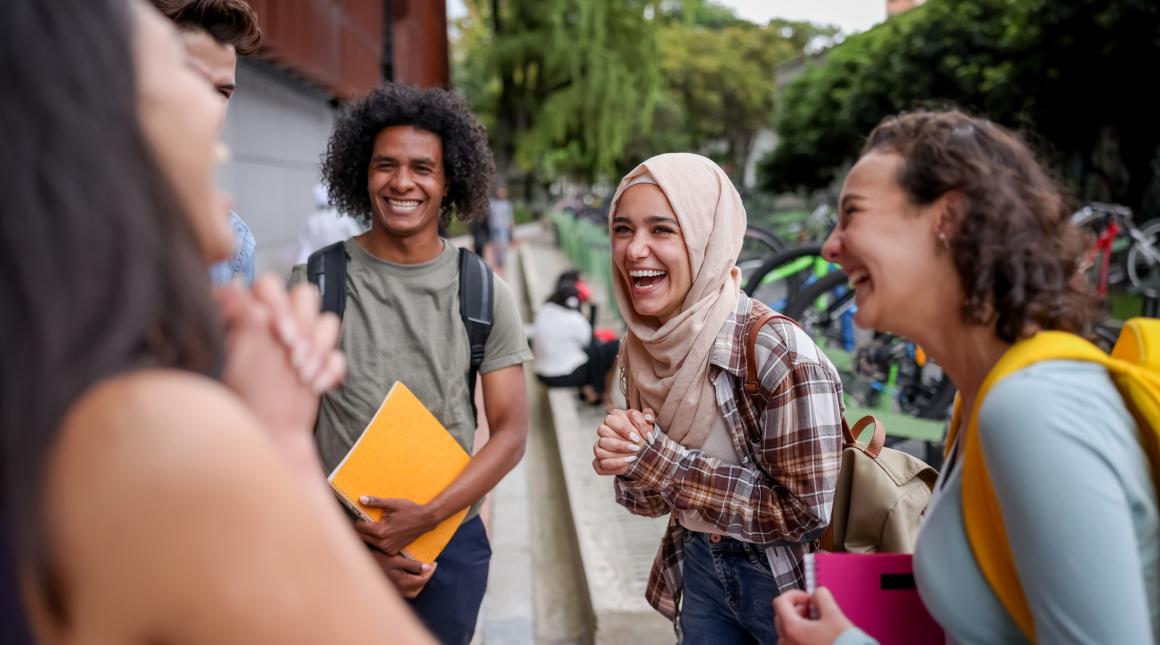 A group of students on campus chatting and laughing