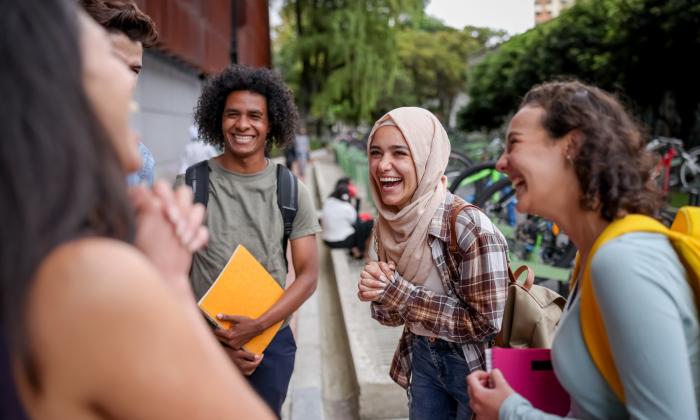 A group of students on campus chatting and laughing